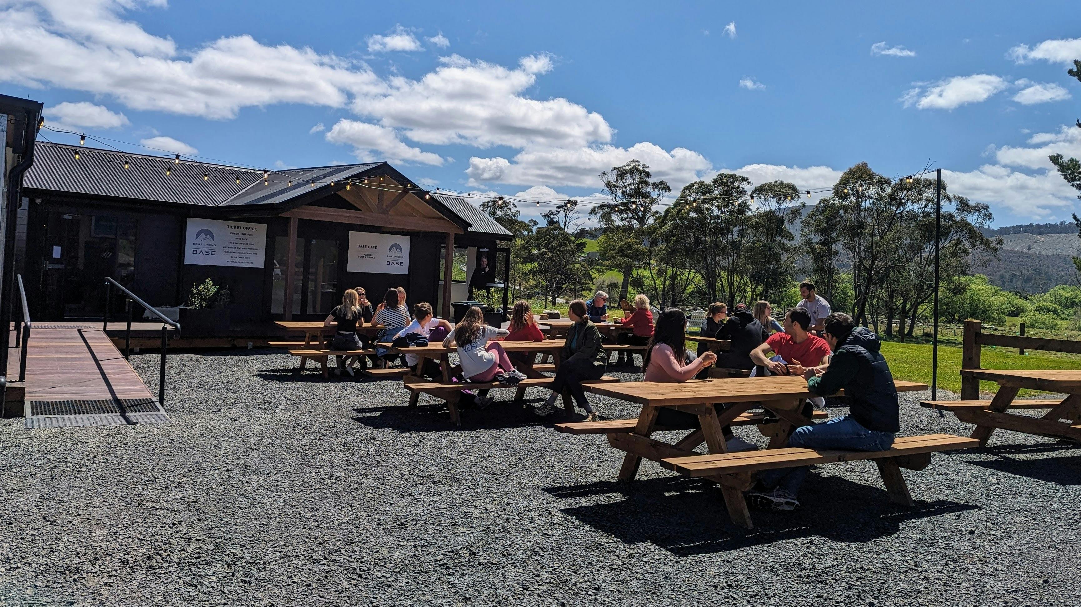 Groups sat on picnic benches outside a cafe