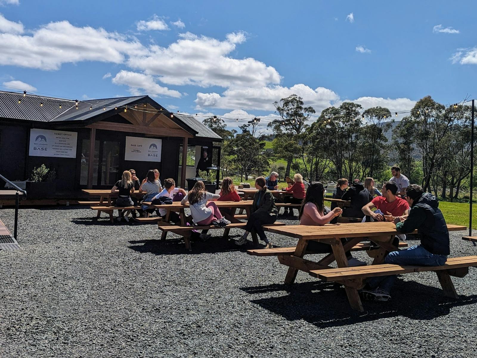 Groups sat on picnic benches outside a cafe