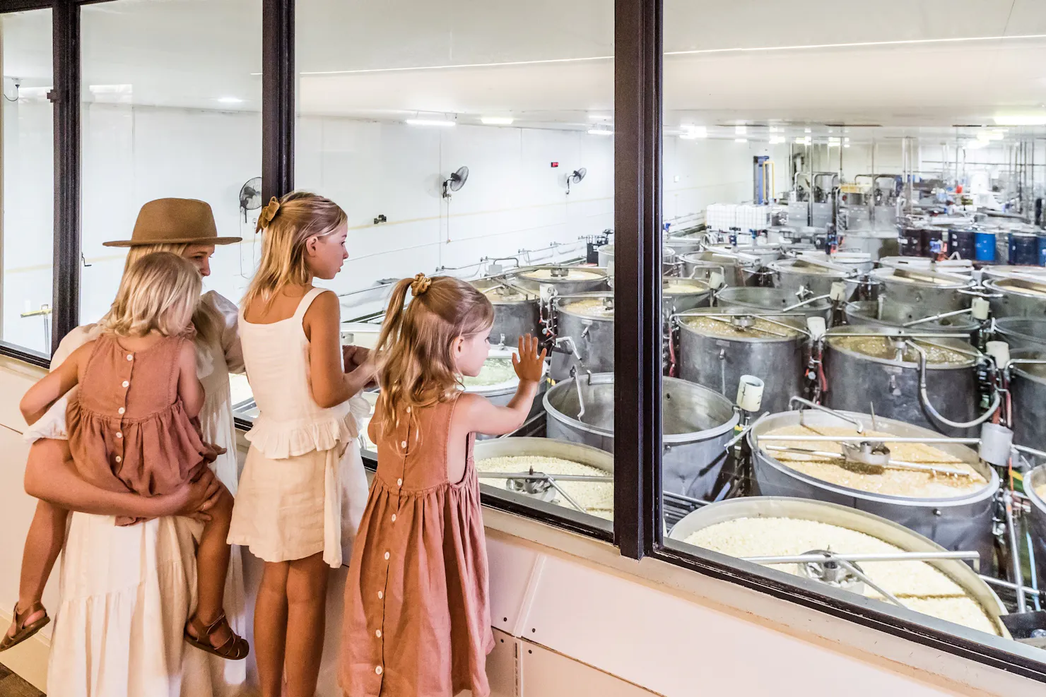 Mum and daughters looking at the syruping tanks