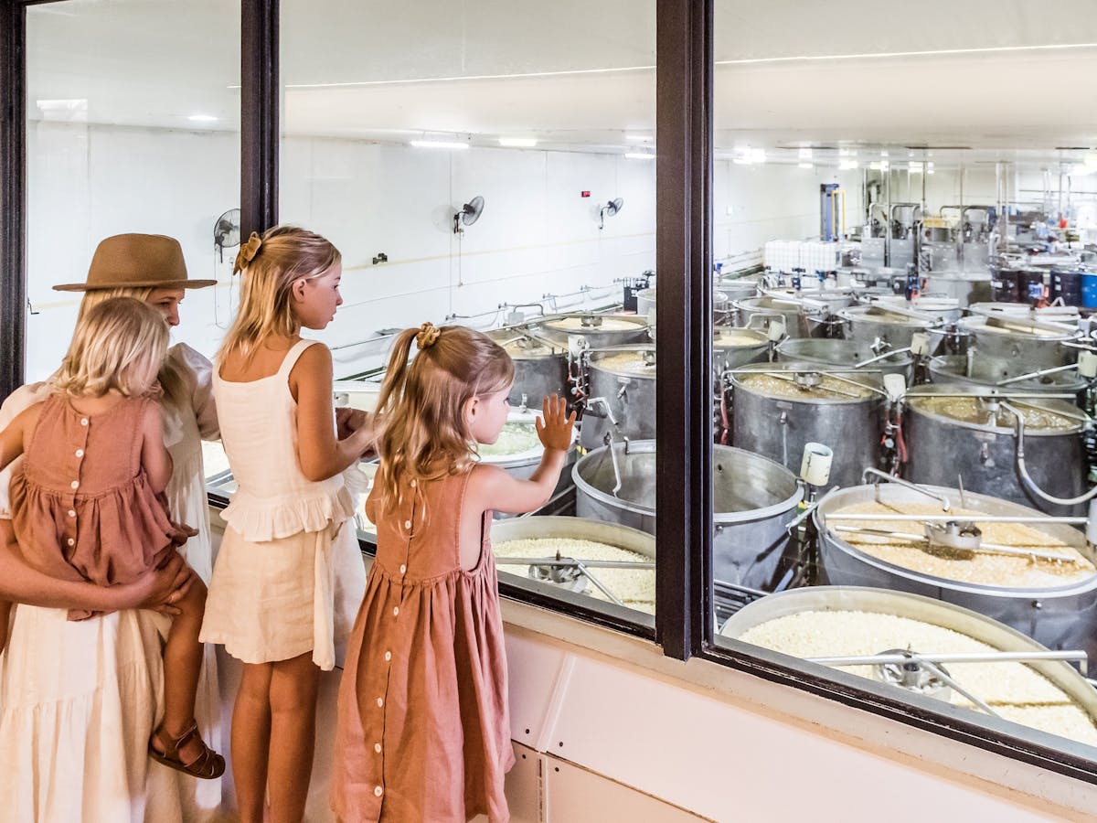 Mum and daughters looking at the syruping tanks