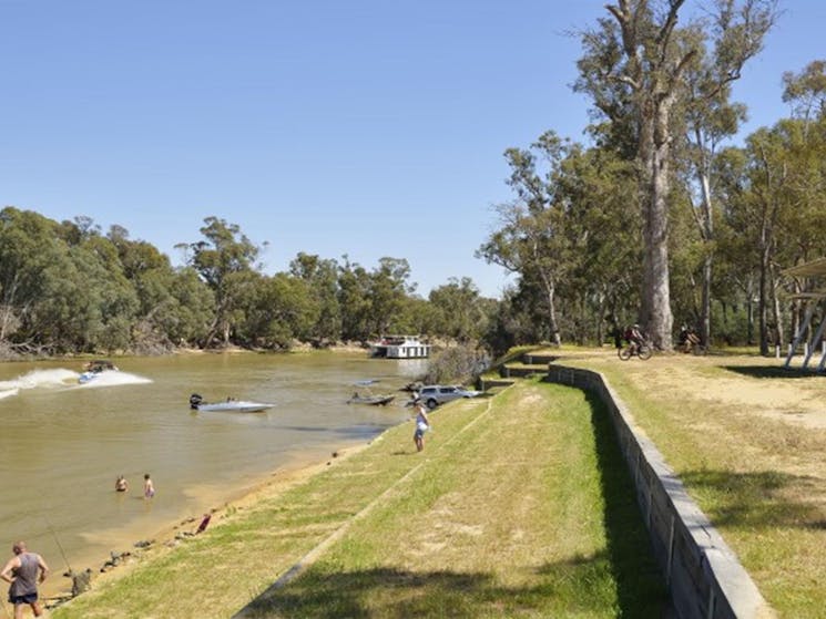 People fishing, paddling and swimming in the river at Five Mile picnic area in Murray Valley