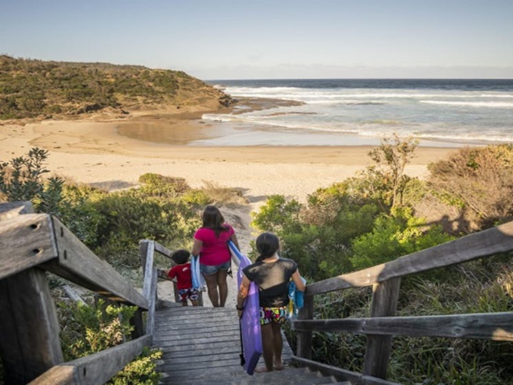 A family walking downstairs to Frazer beach, Munmorah State Conservation Area. Photo: John
