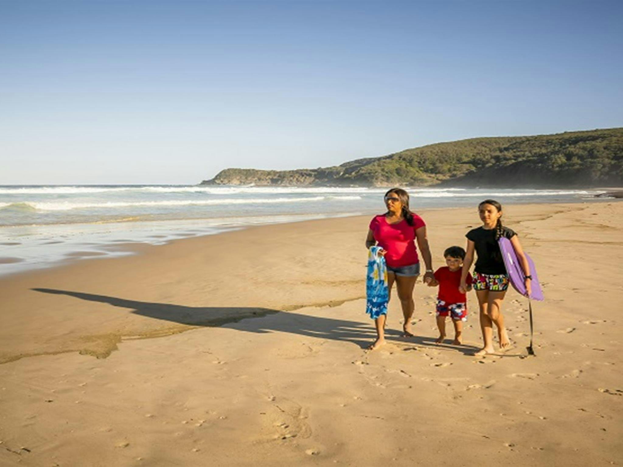 Family walking along Frazer beach, Munmorah State Conservation Area. Photo: John Spencer/OEH