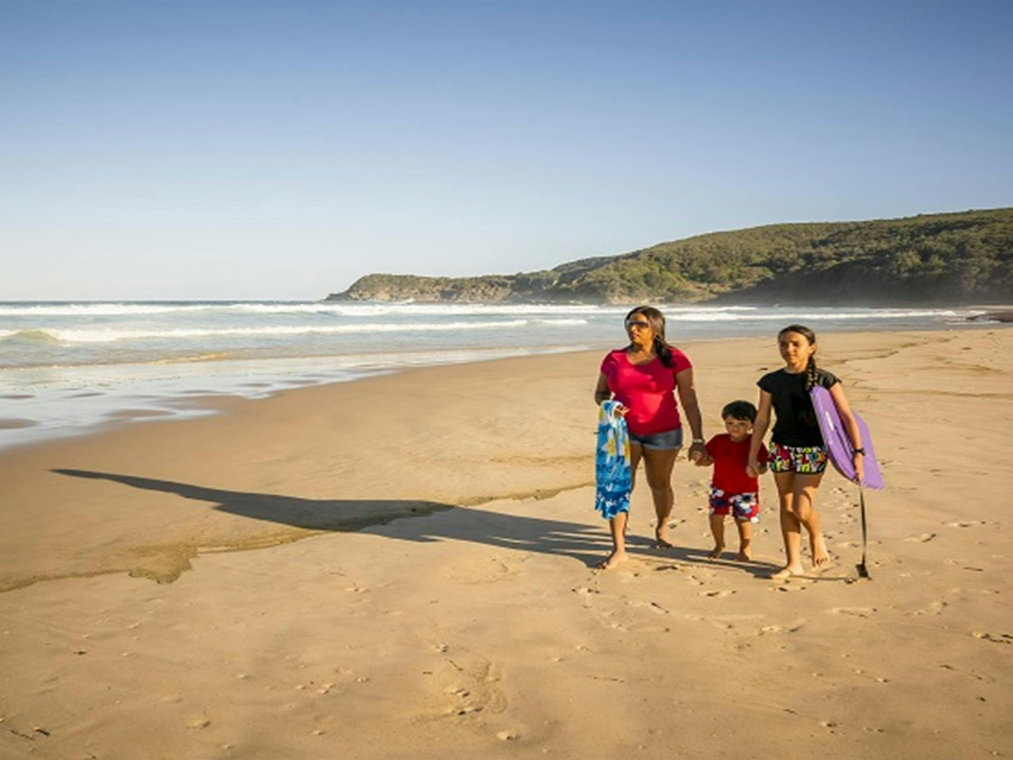 Familie spaziert am Frazer Beach im Naturschutzgebiet Munmorah State Conservation Area. Foto: John Spencer/OEH