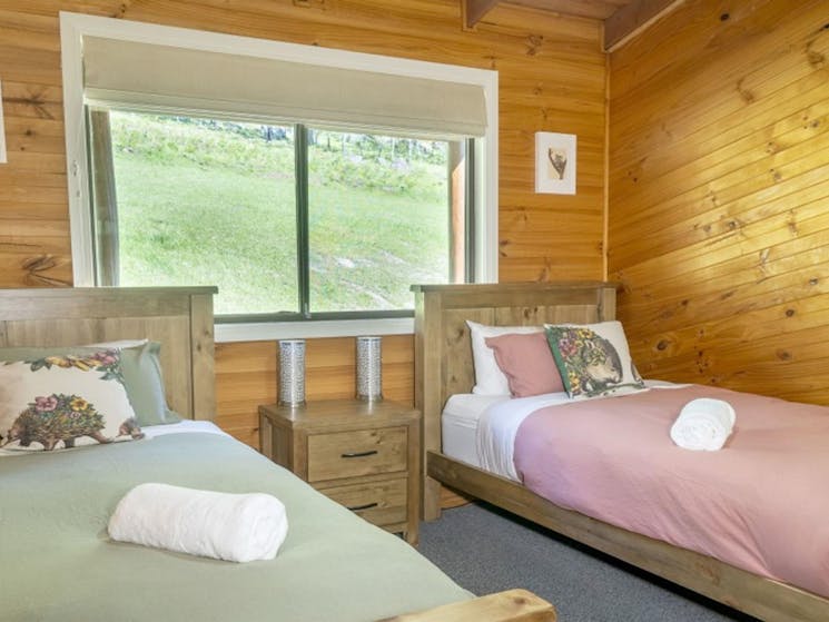 A bedroom with 2 king single beds in Galong cabins, Blue Mountains National Park. Photo: Simone