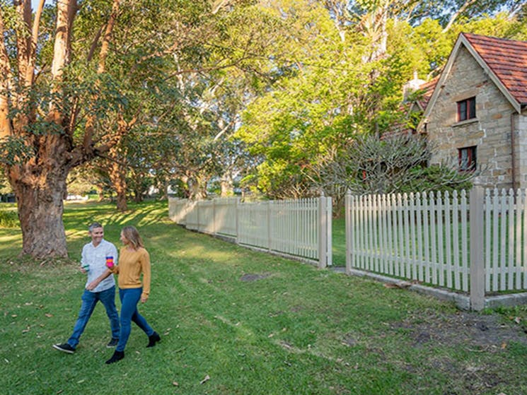 A couple walking out the front gate of Gardeners Cottage in Sydney Harbour National Park. Photo: