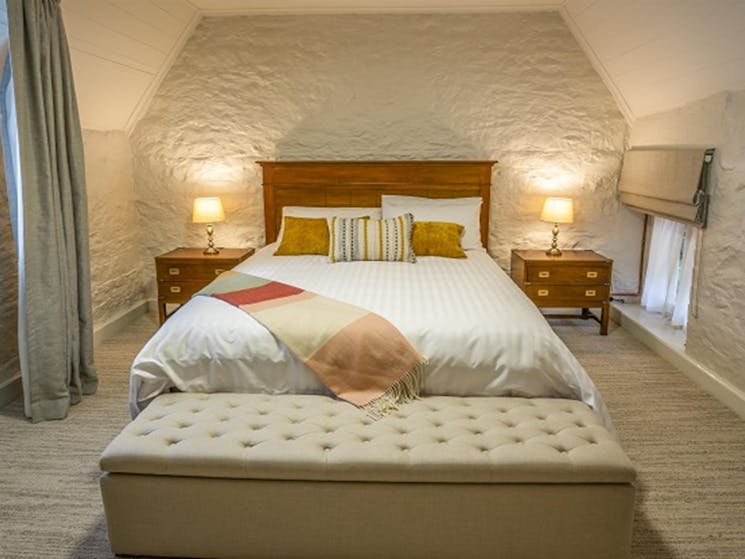 A bedroom with a queen bed in Gardeners Cottage, Sydney Harbour National Park. Photo: John