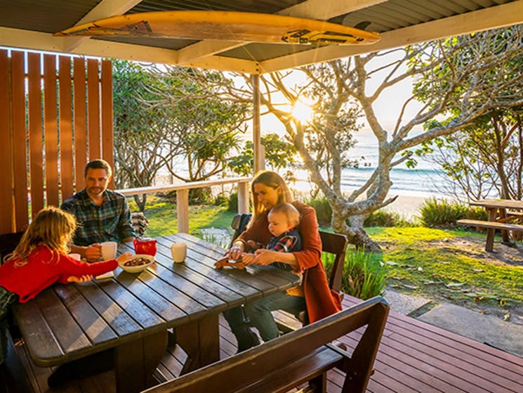 Family on the back deck of Partridge cottage overlooking Byron Bay beach. Photo: DPIE/John Spencer
