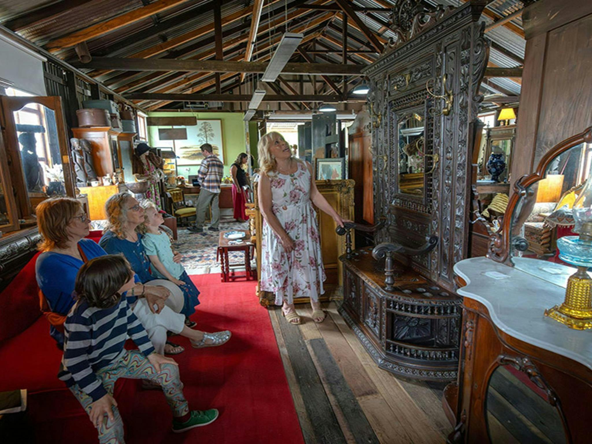 People admiring a large antique mirror inside Gold Rush Antiques at Hartley Historic Site. Credit: