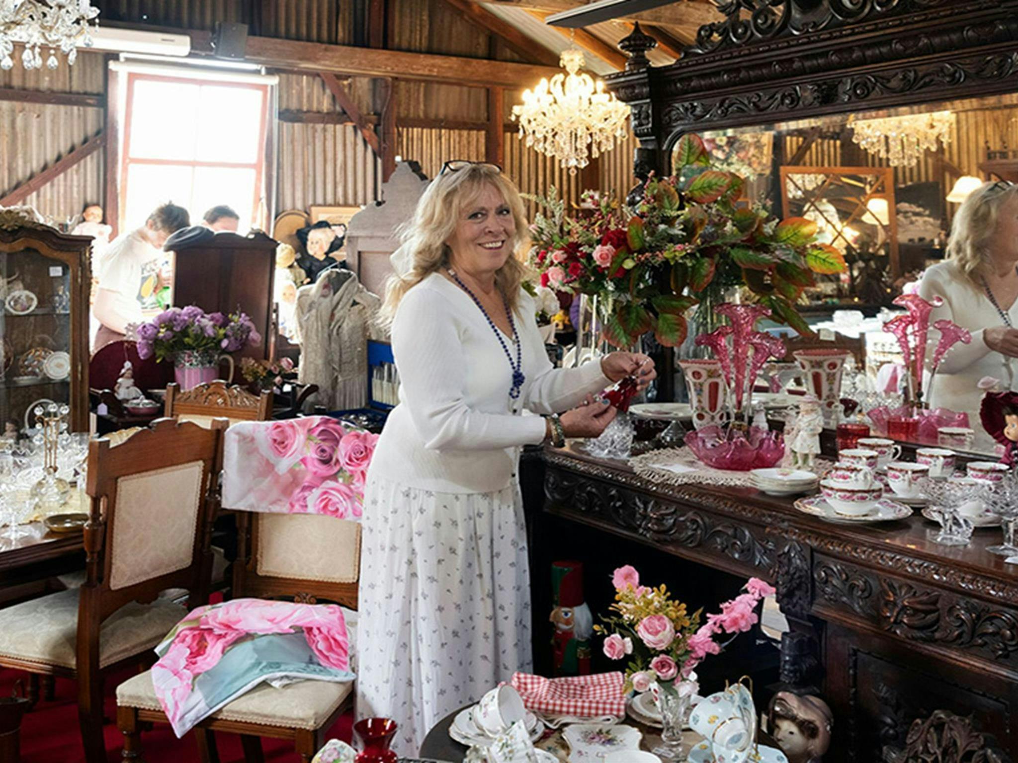 A woman standing among homewares at Gold Rush Antiques in Hartley Historic Site. Credit: Ben Pearse