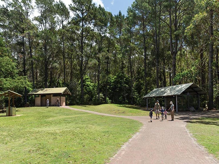 A family pass a picnic shelter at Greenfield Beach picnic area, Jervis Bay National Park. Photo: