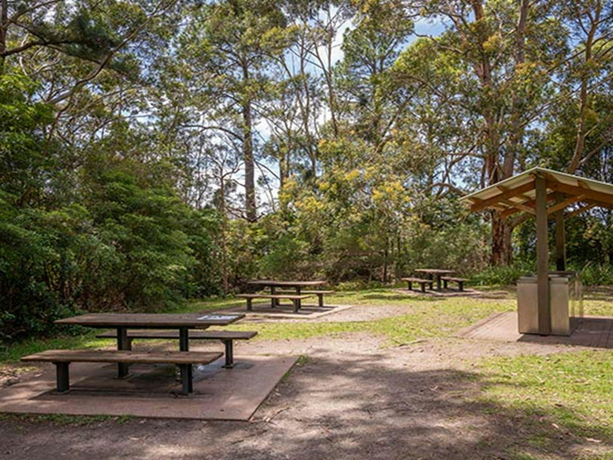 Picnic tables and a covered barbecue at Greenfield Beach picnic area in Jervis Bay National Park.