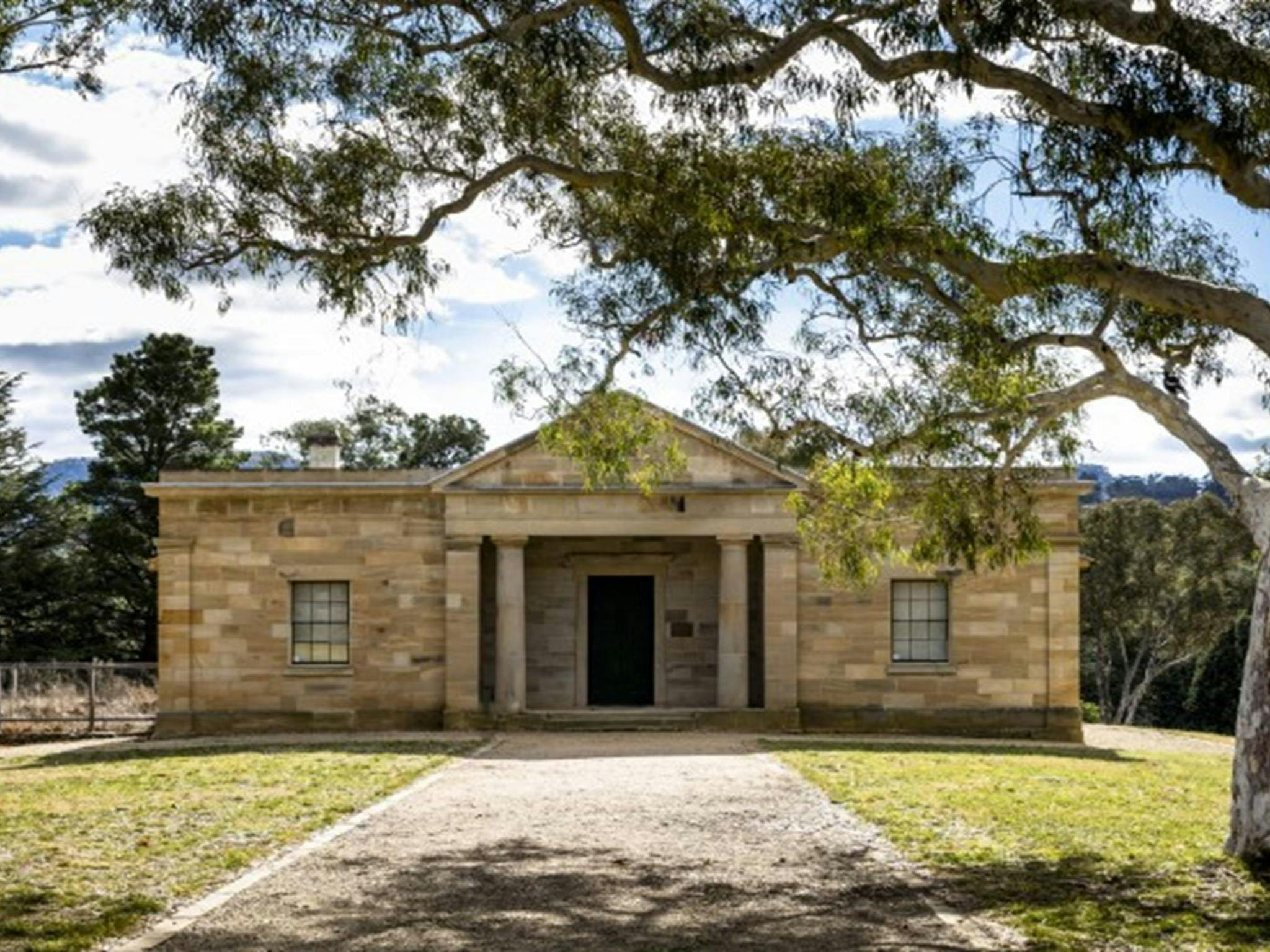 The exterior of Hartley Courthouse, framed by trees in Hartley Historic Site. Photo: Jennifer Leahy