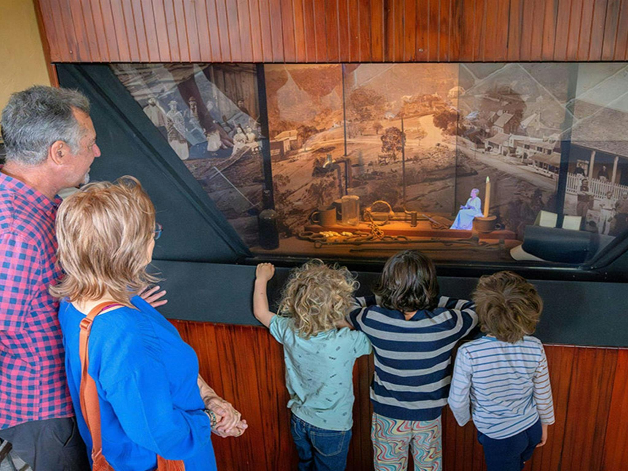 Zwei Erwachsene und drei Kinder sehen sich in Hartley eine Hologramm-Nachstellung des historischen Gerichtsverfahrens an.