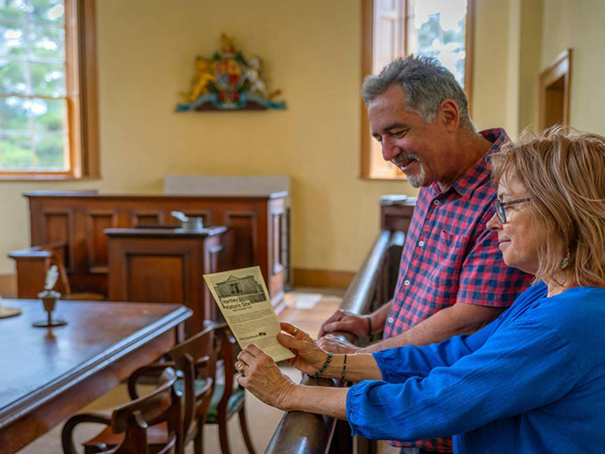Zwei Personen lesen eine Broschüre im Gerichtsgebäude von Hartley auf dem Gelände der historischen Stätte Hartley. Foto: John Spencer