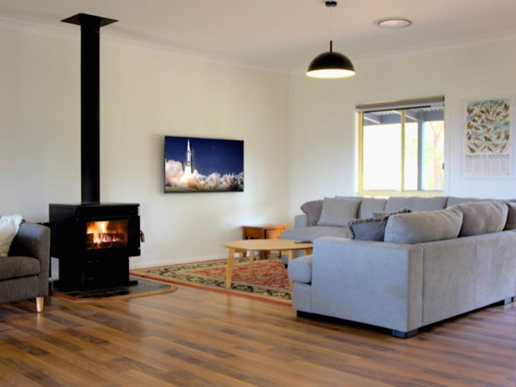 The open-plan living room with indoor fireplace at Honeyeater Homestead in Capertee National Park.
