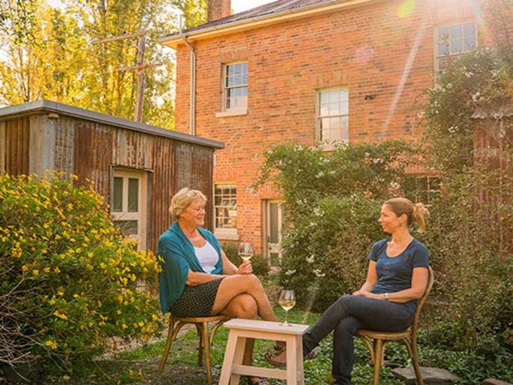Two women enjoy a drink in the garden at Hosies, Hill End Historic Site. Photo: J Spencer/OEH