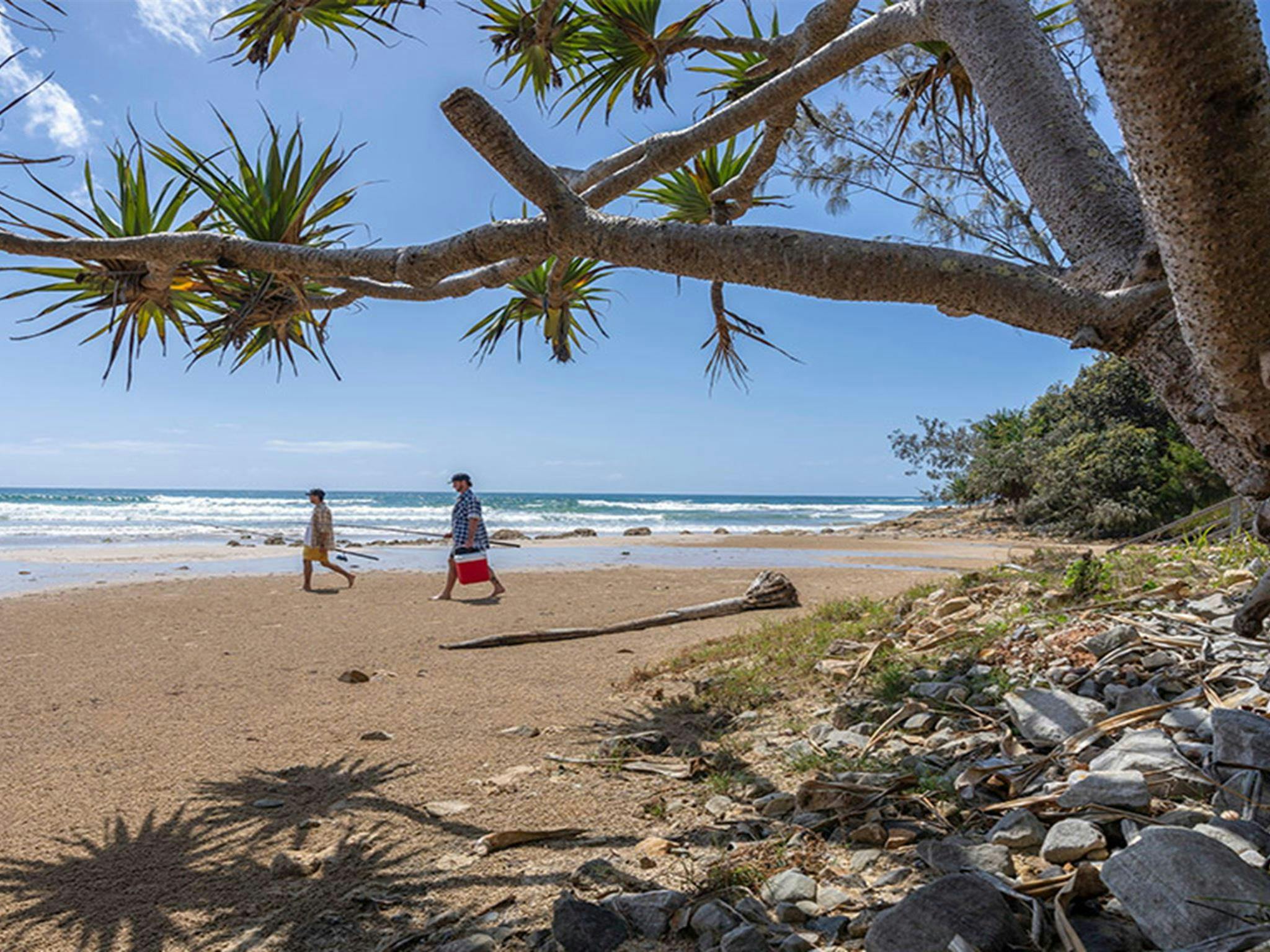 Two people walking on Illaroo-Sandon Beach. Credit: John Spencer &copy; DCCEEW