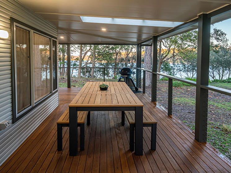 Judges House covered verandah with dining table, seating and a water view, Murramarang National Park