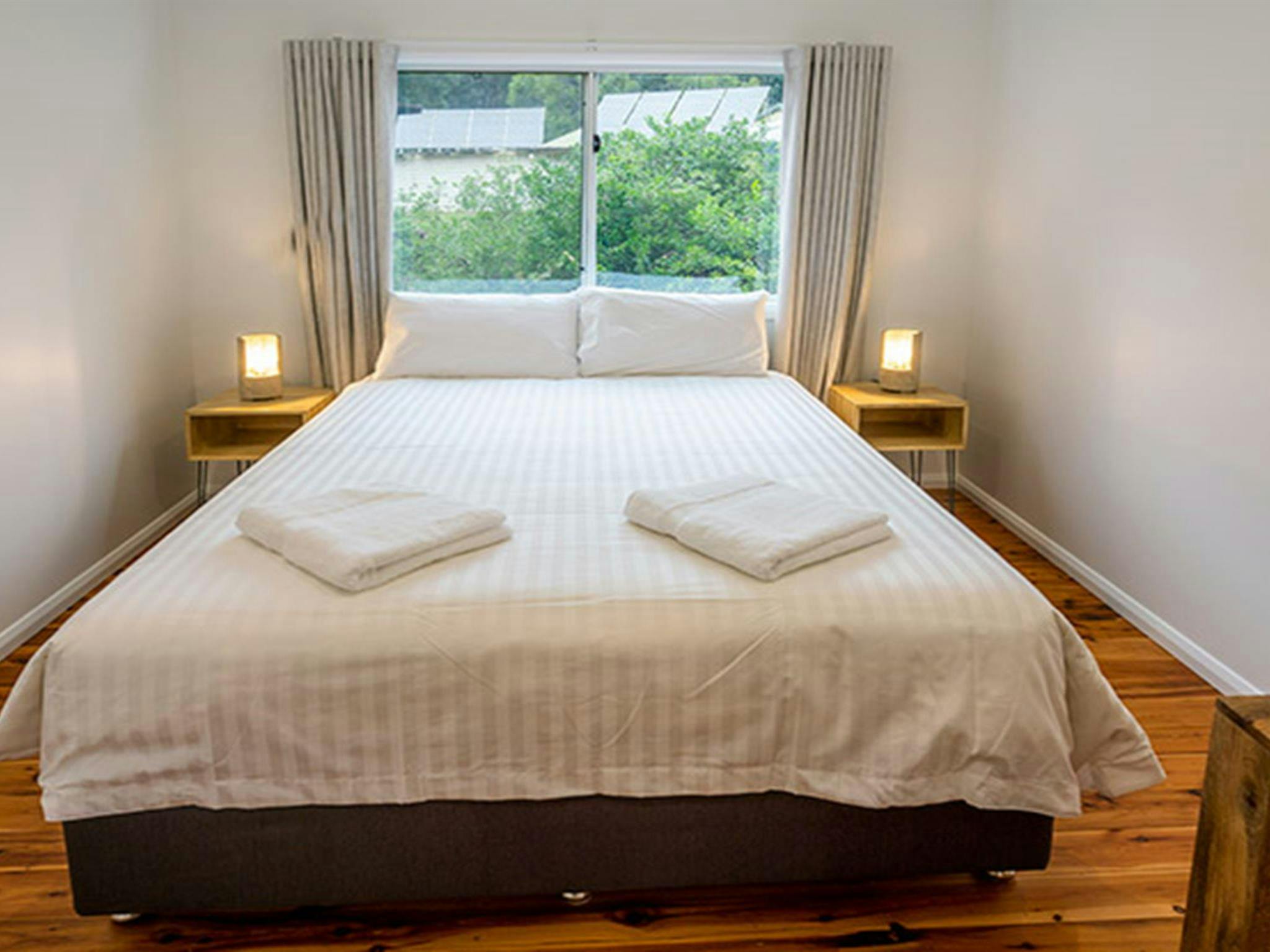 Judges House bedroom with queen bed and back wall window, Murramarang National Park. Photo: John