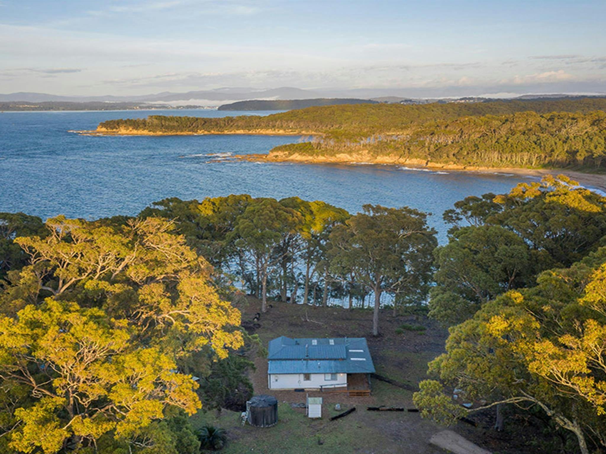 Aerial view of Judges House and the surrounding ocean and headlands. Photo: John Spencer &copy;DPIE