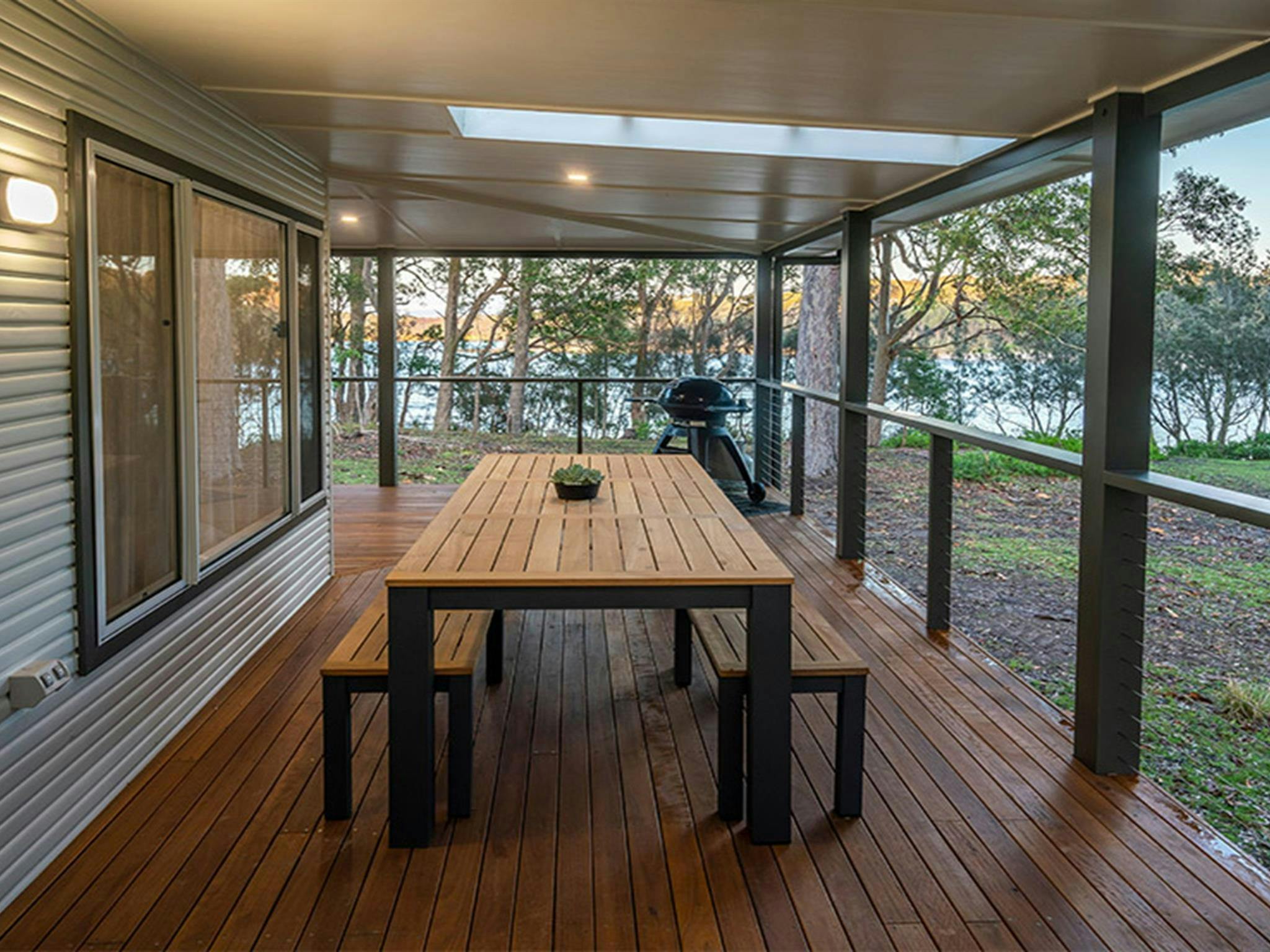 Judges House covered verandah with dining table, seating and a water view. Photo: John Spencer
