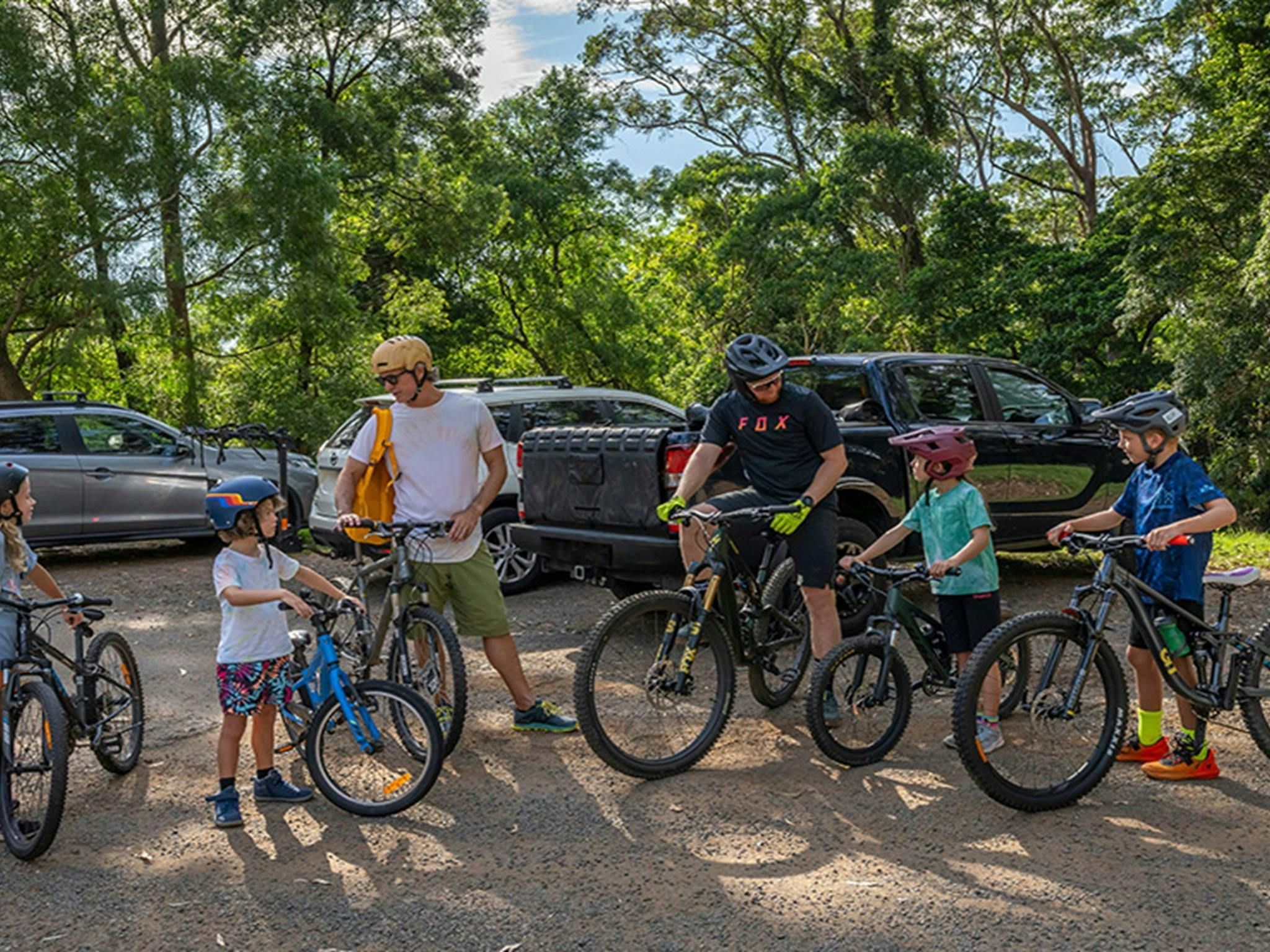 Two dads with 4 young kids on bikes set off from the carpark for a big day of riding. Credit: John