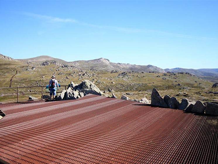 A man enjoys alpine views at Kosciuszko lookout along Thredbo's Kosciuszko walk. Photo: Elinor