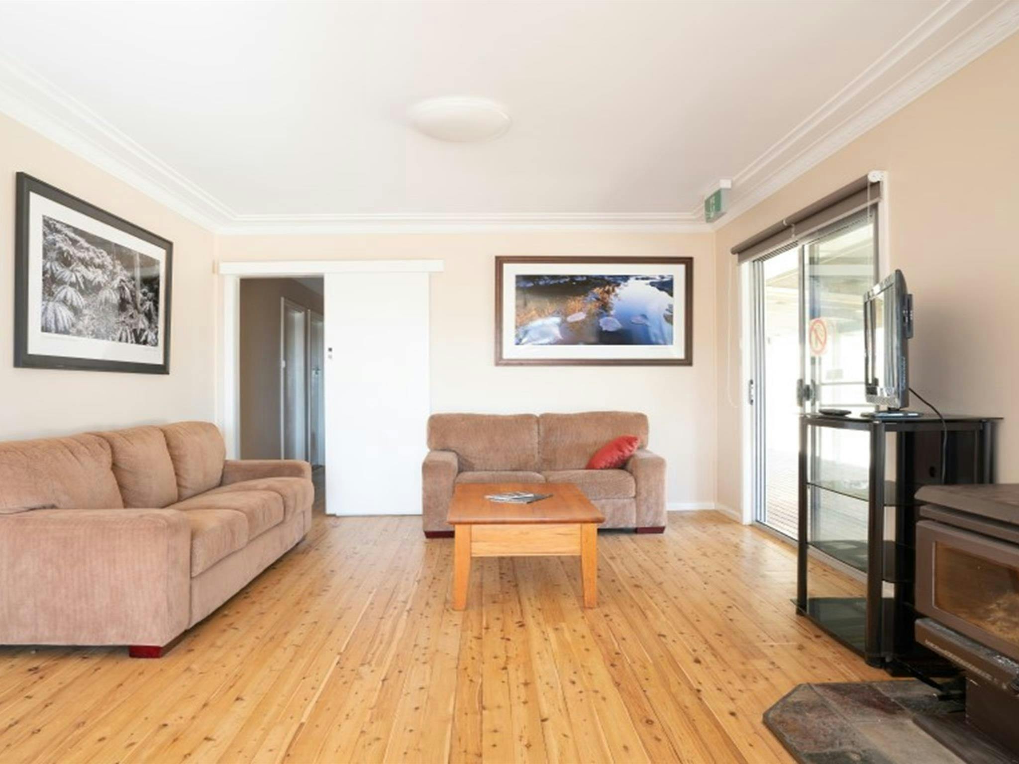 The lounge room with couches and fireplace in Lavender Vale Cottage, Kwiambal National Park. Photo