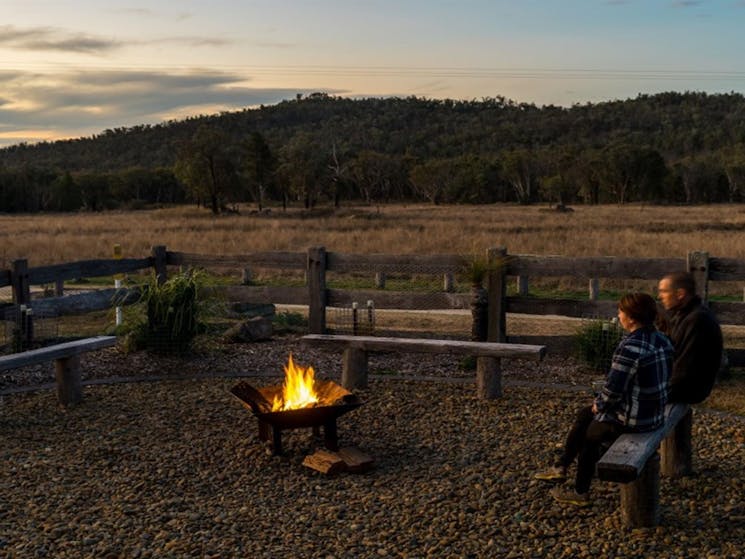 2 people sitting on a bench by the firepit at Lavender Vale Homestead. Photo &copy; DPE