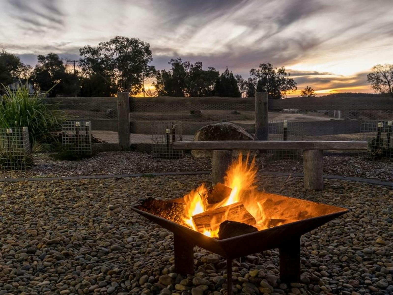 A lit firepit against the backdrop of Kwiambal National Park at Lavender Vale Cottage. Photo ©