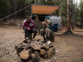 Two campers enjoying morning coffee at the Running Brook campsite.