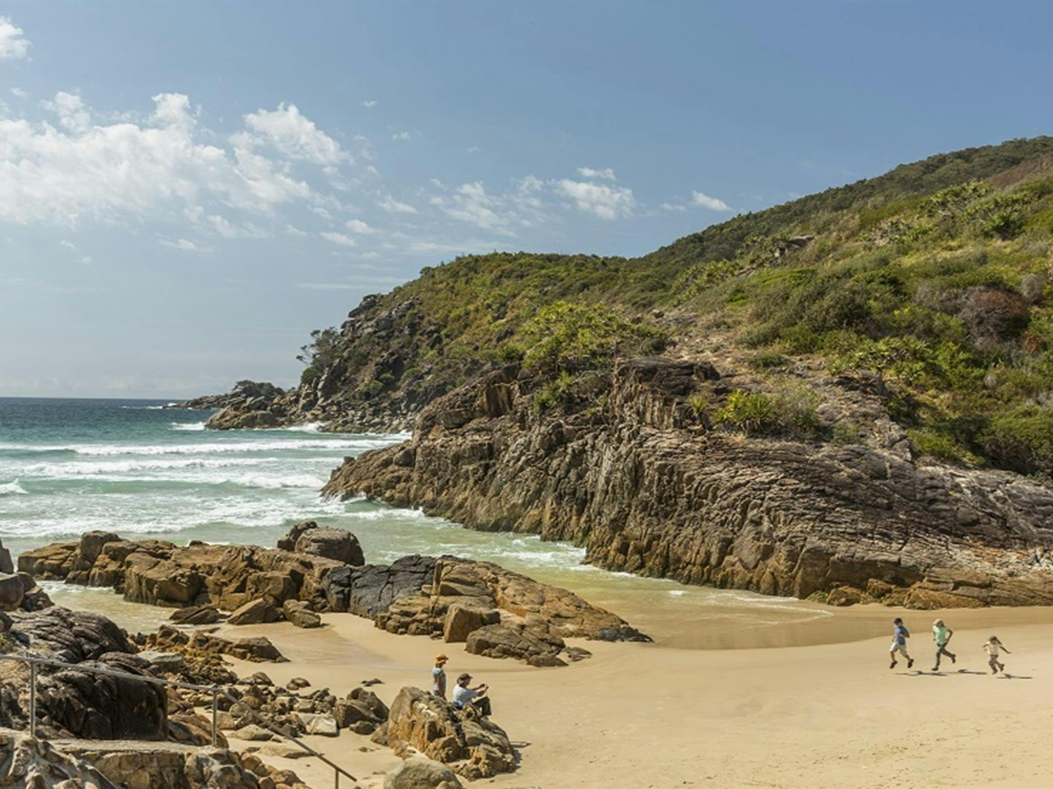 Family running along Little Bay beach, Arakoon National Park. Photo: David Finnegan/DPE