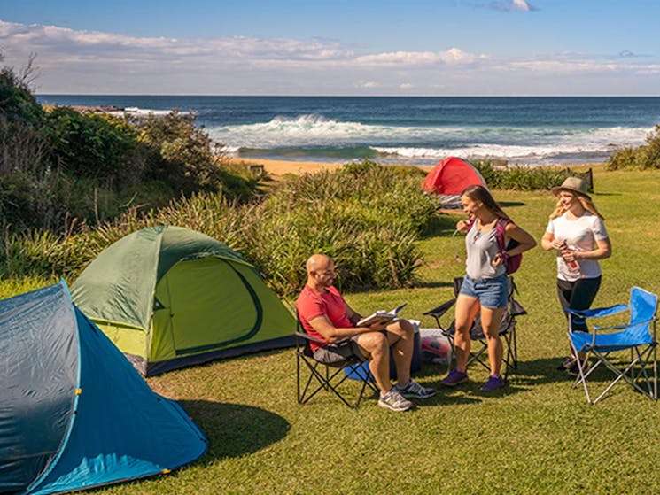 People nearby tents located at Little Beach campground, Bouddi National Park. Photo: John