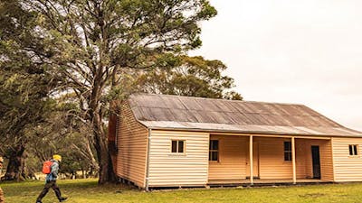 Two men walk towards Long Plain Hut in the High Plains area of Kosciuszko National Park. Photo: