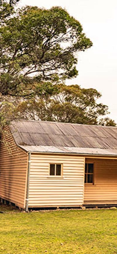 Two men walk towards Long Plain Hut in the High Plains area of Kosciuszko National Park. Photo: