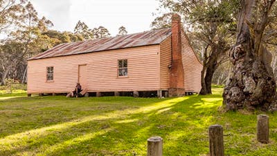A man sits on steps outside Long Plain Hut, High Plains area, Kosciuszko National Park. Photo: