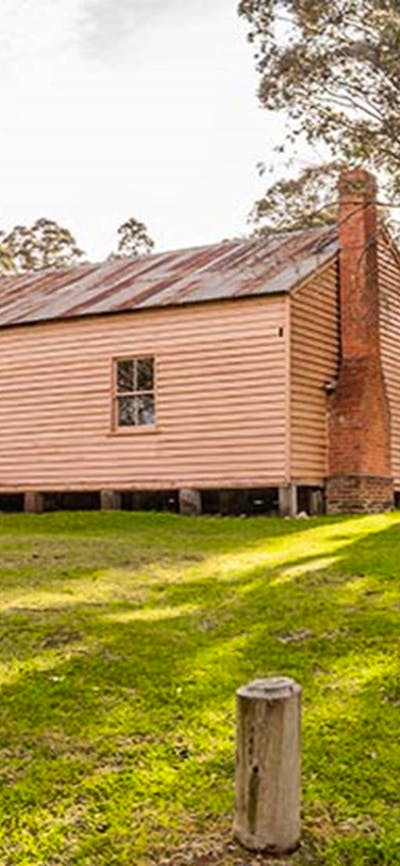 A man sits on steps outside Long Plain Hut, High Plains area, Kosciuszko National Park. Photo: