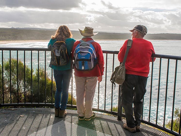 Bushwalkers looking along the coastline at Meroo Head Lookout, Meroo National Park. Photo: Michael