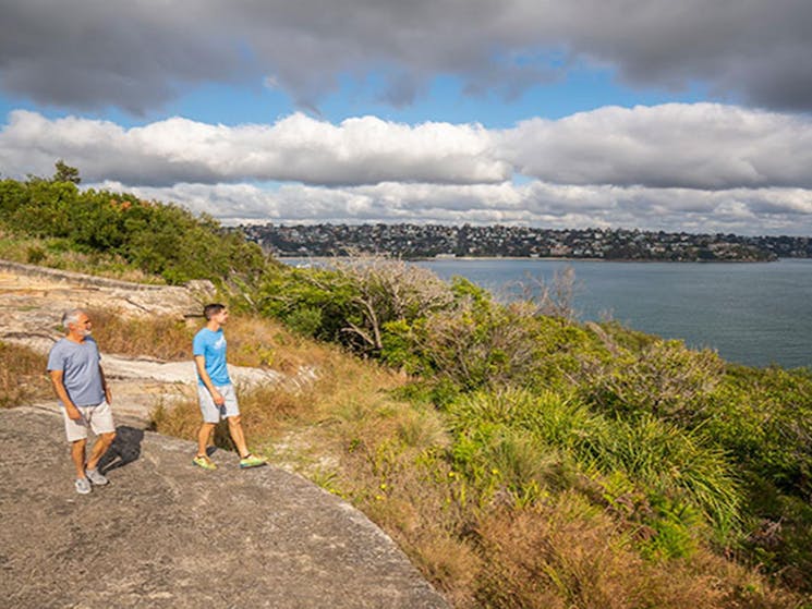 Two people looking out over the harbour at Middle Head forts in Sydney Harbour National Park. Photo: