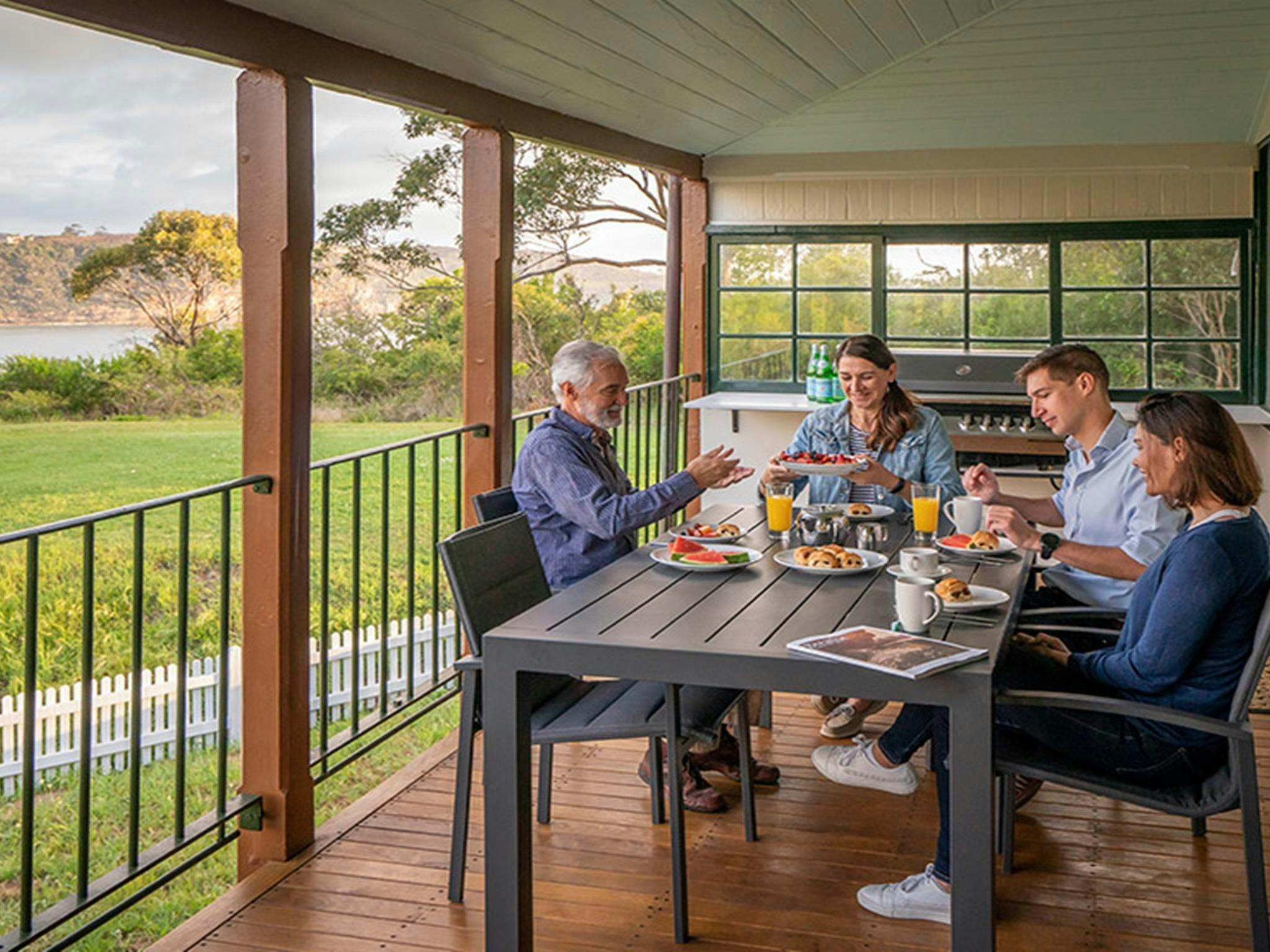 Guests eating on the balcony at Middle Head Officers Quarters. Credit: John Spencer &copy; DCCEEW