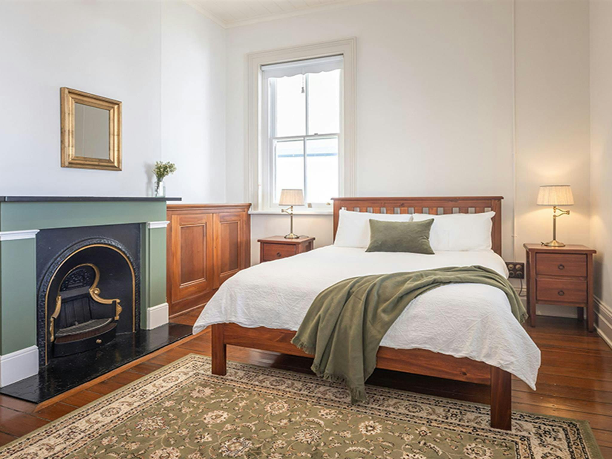 A bedroom with old fireplace in Montague Island Assistant Lighthouse Keeper's Cottage. Photo &copy;