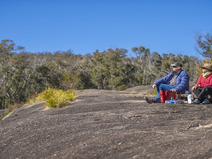 Visitors sitting on the granite rock formations at Morgans Gully picnic area. Photo: Joshua J &copy;