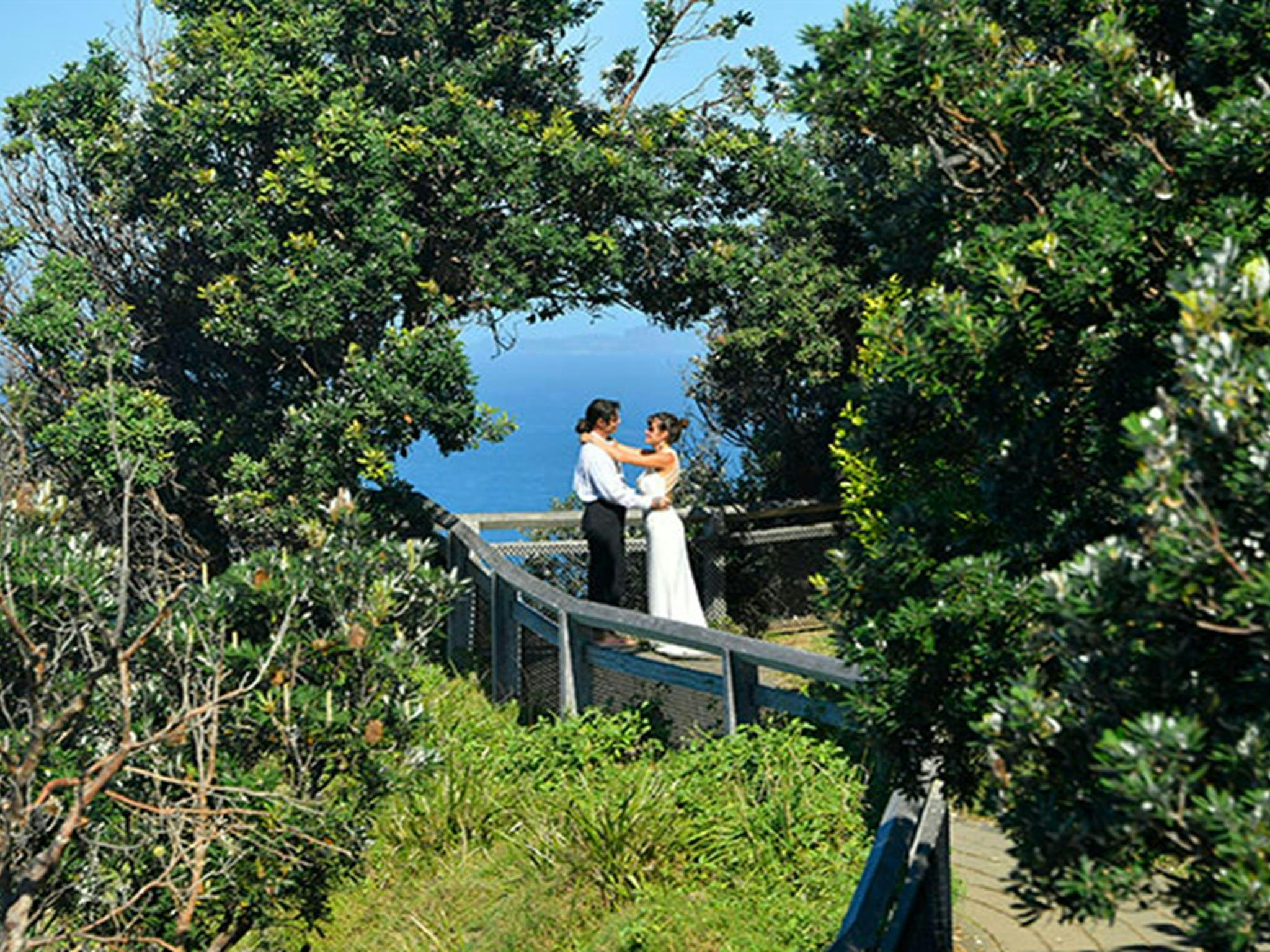 一对情侣站在纽约州拜伦角最东端由树木形成的天然拱门下。