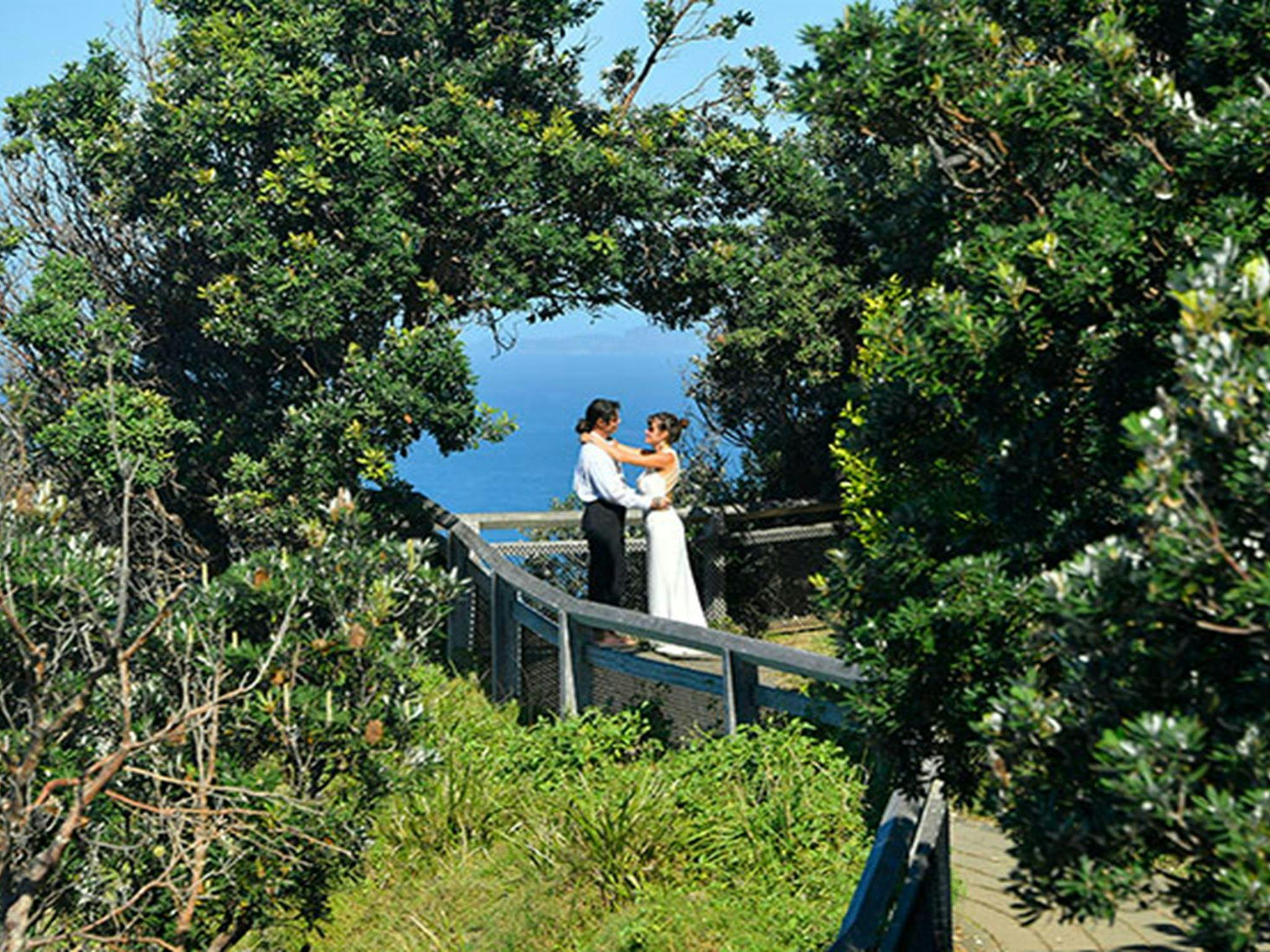 케이프 바이런 주의 가장 동쪽 지점에 있는 나무들이 만든 자연 아치 아래 서 있는 커플