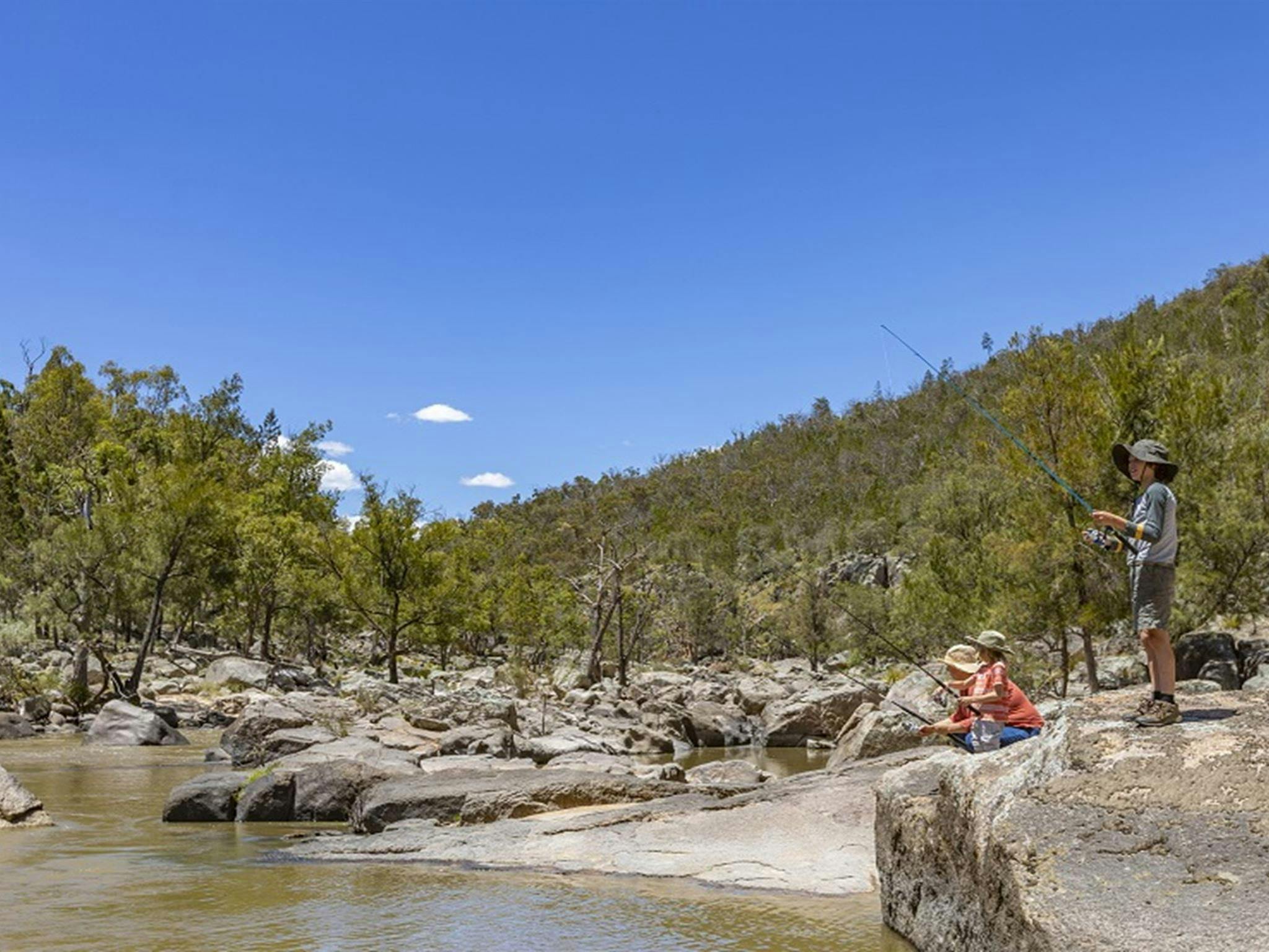 A family enjoy fishing at the edge of Naomi River, Warrabah National Park. Photo: Joshua Smith