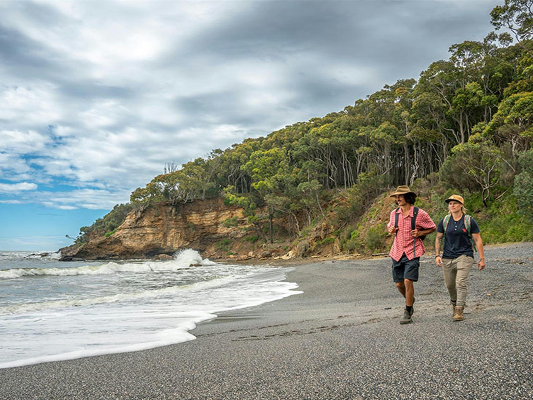 Zwei Personen spazieren am Dark Beach im Murramarang-Nationalpark. Foto: John Spencer © DPE