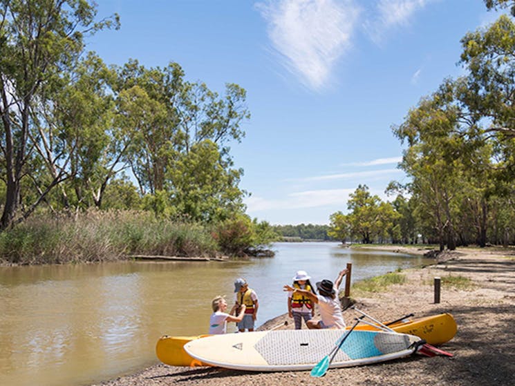 Family with lifejackets, paddle boards, canoe and paddles at Barmah Lakes day visitor area. Photo: B