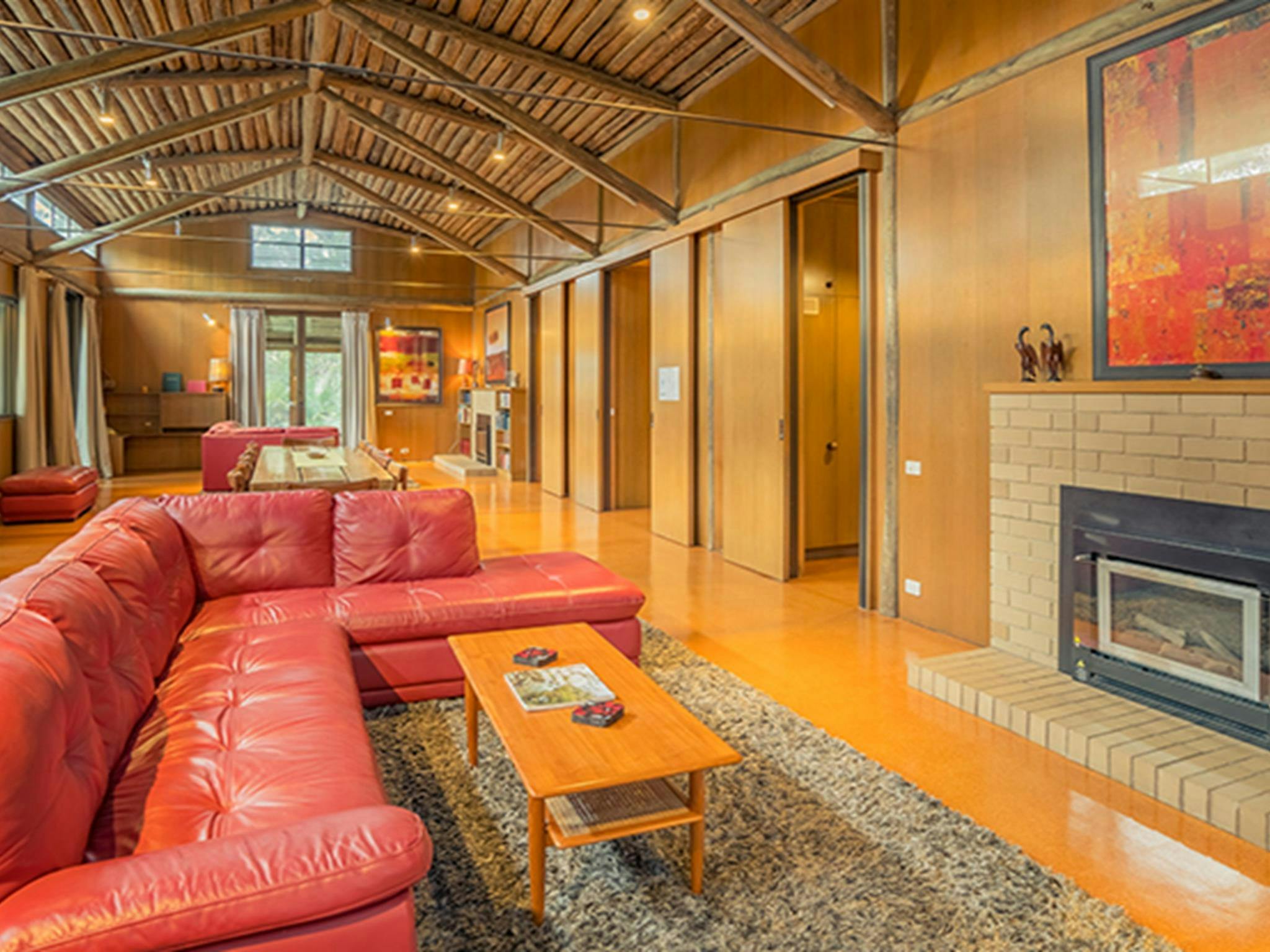 迈尔大厦休息室里的红色皮沙发、壁炉和地毯。照片：OEH/John Spencer