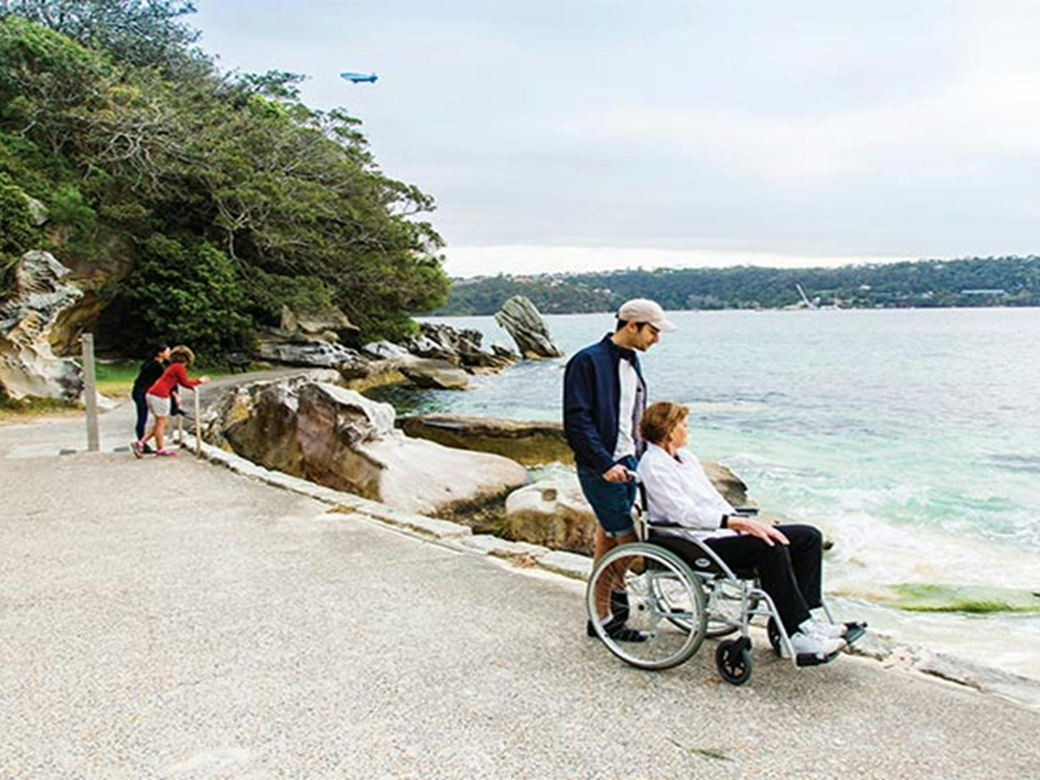 Wheelchair user admiring views of Shark Beach from the wheelchair accessible path in Nielsen Park.